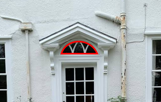 Semicircular fanlight with radiating bars over a front door, outlined