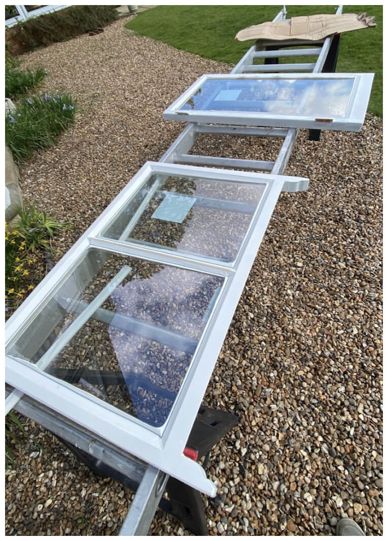 Reglazed sashes laid on trestles in the garden, ready to go back into the frame