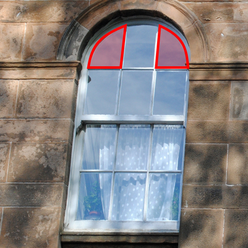 Arched-head sash window in a stone wall with the arched panes outlined