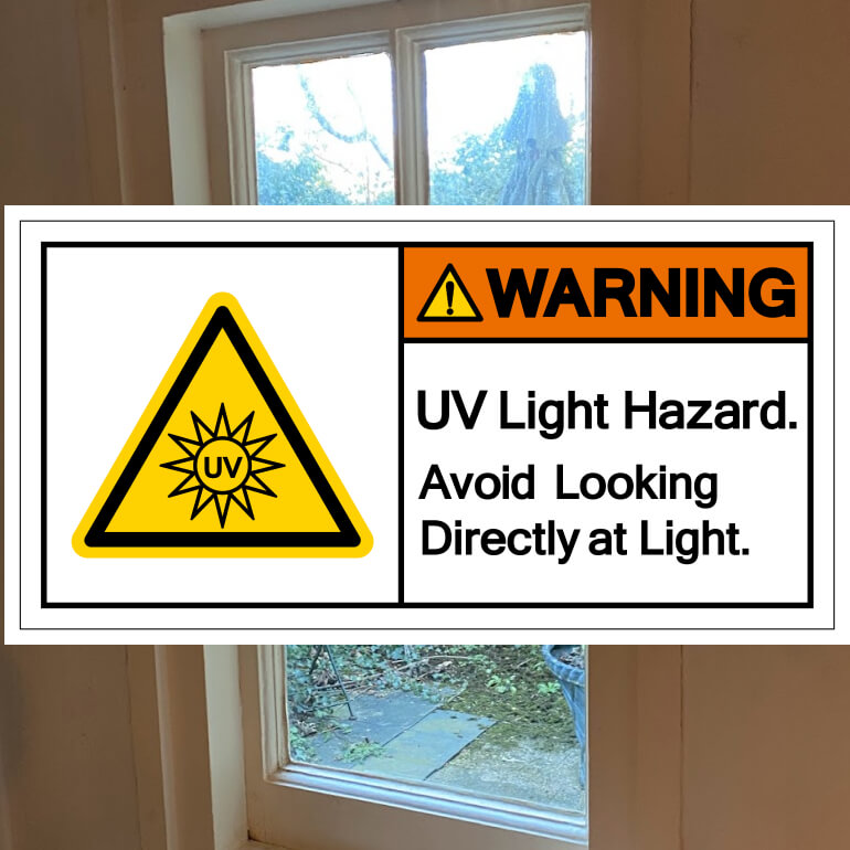 UV light hazard warning sign beside a sunlit window