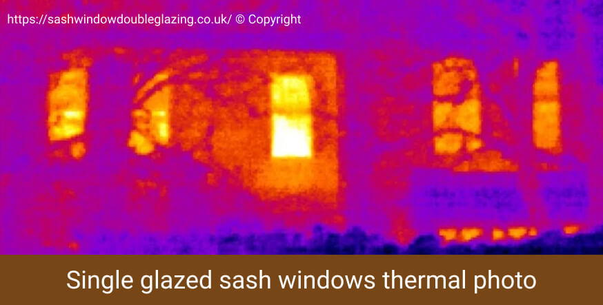 Thermal imaging photo of single glazed sash windows glowing with heat loss